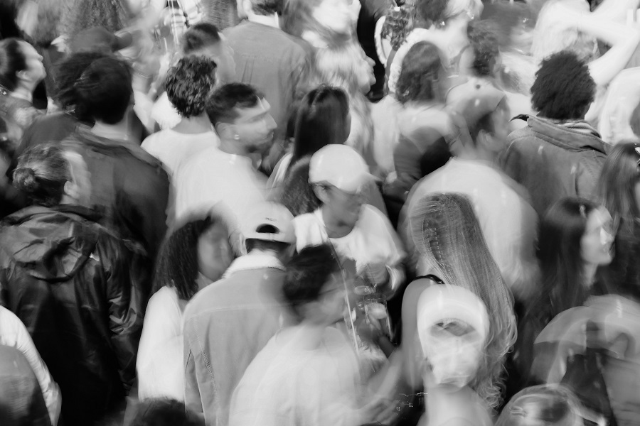 Schwarz-weiß Foto von einer Menschenmenge, die Personen sind in Bewegung und dadurch etwas verschwommen