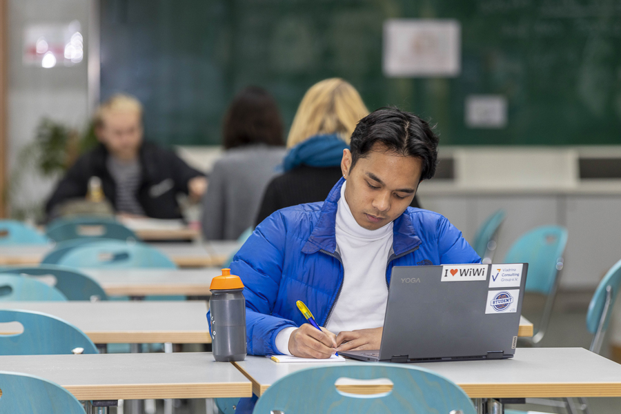 Viadrina-Student arbeitet in der Mensa an seinem Laptop