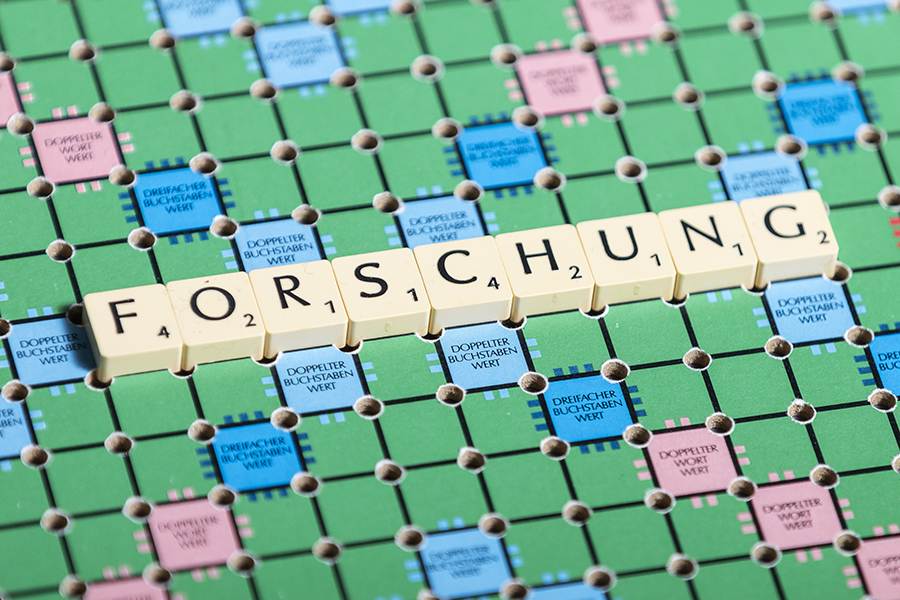 Wort "Forschung" auf Scrabble-Brett, Ansicht von oben, Großaufnahme